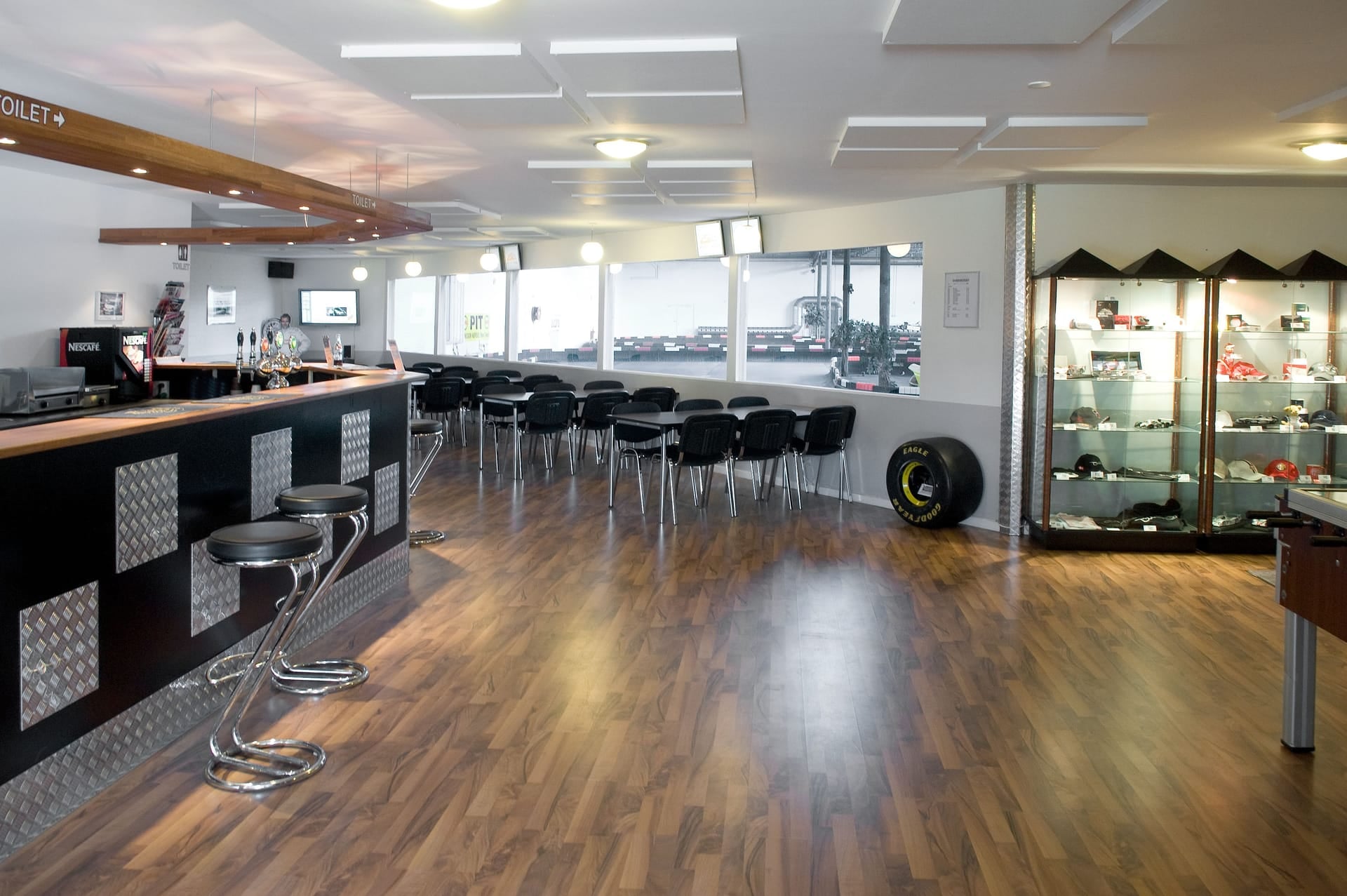 Lounge med bar, pokaler og udsigt over gokartbanen